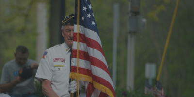 A man in uniform holding an american flag.
